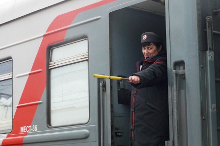 La provodnitsa chef de train donne le départ d'un TransSib en gare de Tyumen
